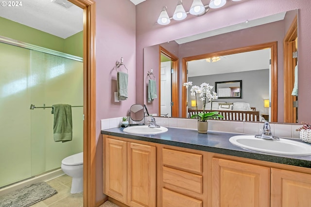 bathroom with toilet, an enclosed shower, vanity, and tile patterned flooring