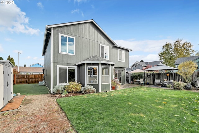 back of house featuring a patio, a gazebo, and a yard