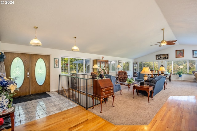 living room with vaulted ceiling, ceiling fan, and light wood-type flooring