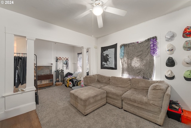 living room featuring wood-type flooring, ceiling fan, and decorative columns