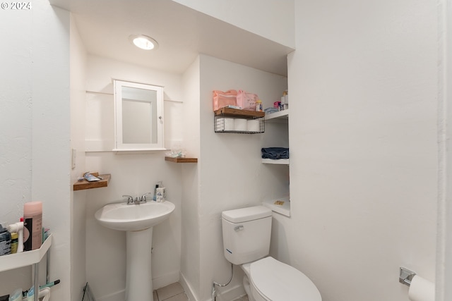 bathroom featuring toilet, tile patterned flooring, and sink