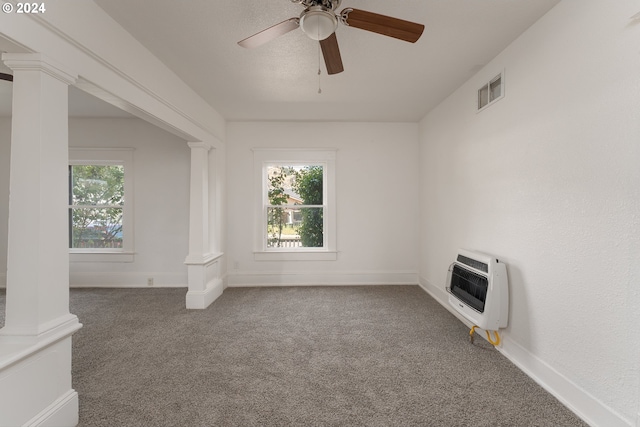 unfurnished room with a healthy amount of sunlight, ceiling fan, heating unit, and carpet