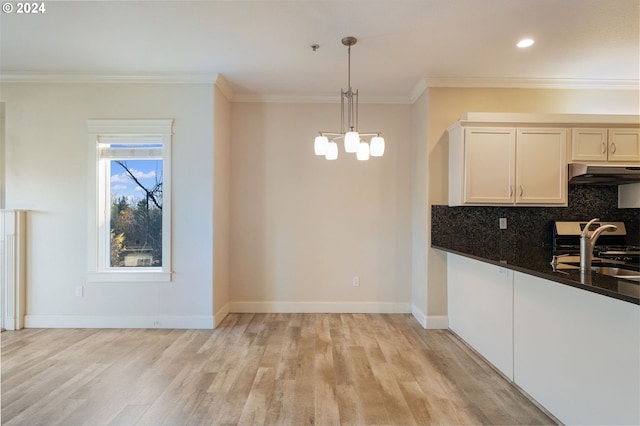 kitchen featuring hanging light fixtures, tasteful backsplash, light hardwood / wood-style flooring, a notable chandelier, and white cabinets