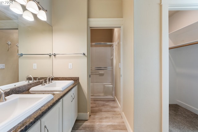 bathroom featuring vanity, a shower with shower door, and wood-type flooring