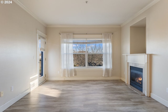 unfurnished living room featuring ornamental molding and light wood-type flooring