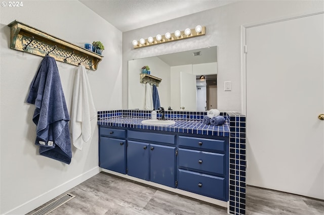 bathroom featuring a textured ceiling, vanity, and hardwood / wood-style flooring