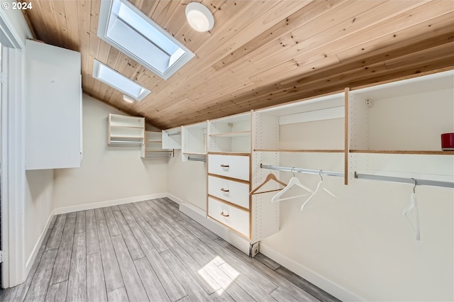 spacious closet featuring lofted ceiling with skylight and light hardwood / wood-style flooring