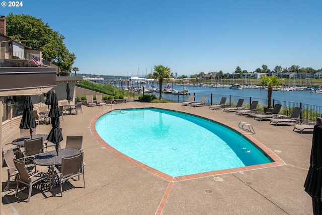 view of pool with a patio area and a water view