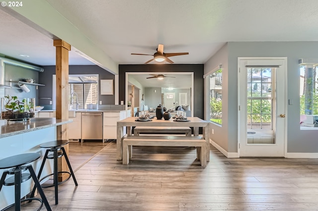 dining space with hardwood / wood-style floors, decorative columns, and ceiling fan