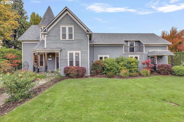 view of front of property with a front lawn and roof with shingles