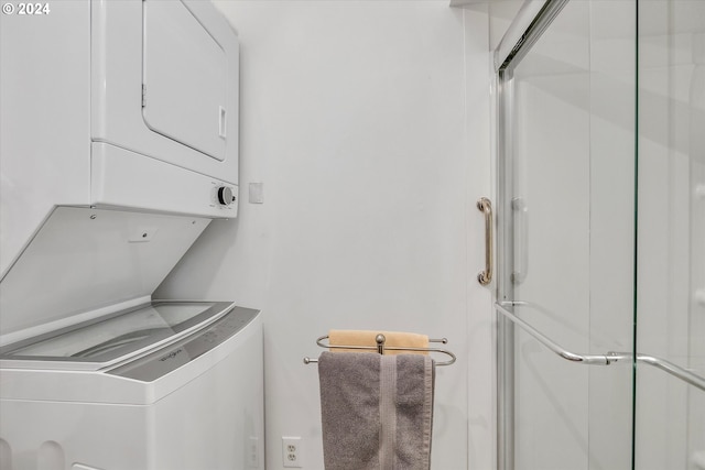 washroom featuring stacked washer / dryer and laundry area