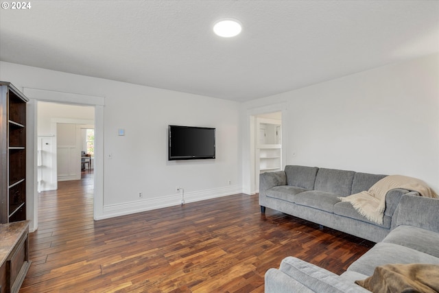 living area featuring baseboards and dark wood-style floors