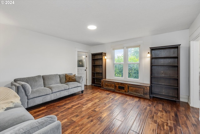 living room with a textured ceiling and dark hardwood / wood-style flooring