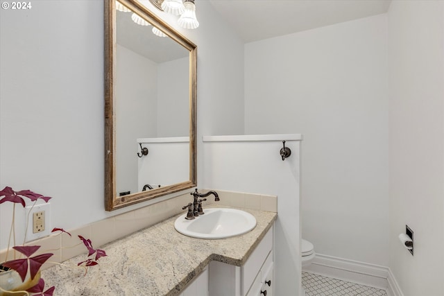 bathroom featuring toilet, vanity, tile patterned floors, and baseboards