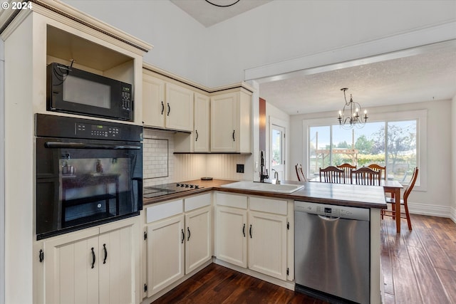 kitchen featuring a sink, dark wood-type flooring, black appliances, a peninsula, and a notable chandelier