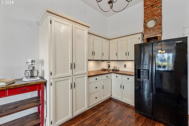 kitchen with dark wood-type flooring, brick wall, cream cabinets, and black fridge with ice dispenser