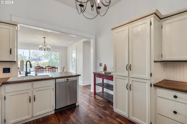 kitchen featuring dark wood-style floors, stainless steel dishwasher, a sink, butcher block counters, and a chandelier