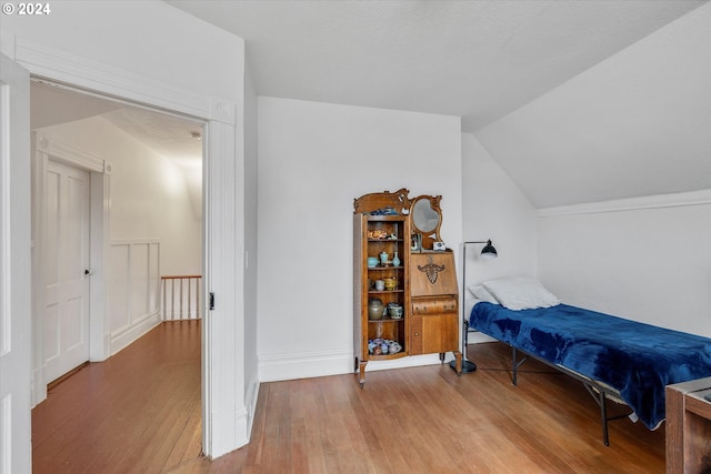 bedroom featuring lofted ceiling and hardwood / wood-style floors