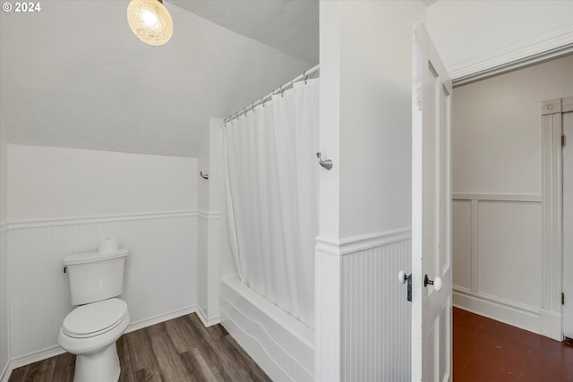 full bath featuring a decorative wall, wood finished floors, wainscoting, toilet, and lofted ceiling