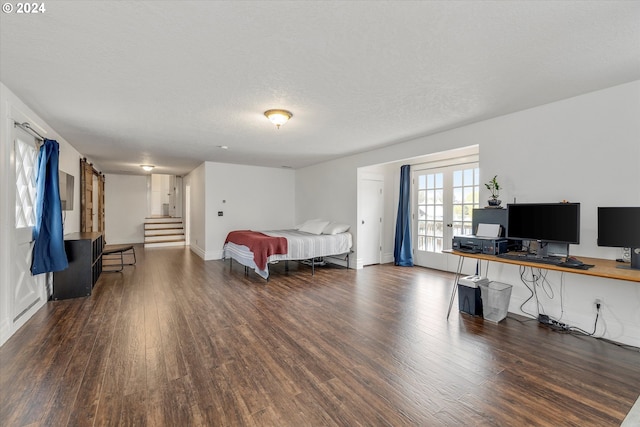 bedroom with a textured ceiling and dark hardwood / wood-style floors