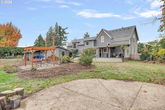 rear view of house with a pergola, a patio area, a lawn, and fence