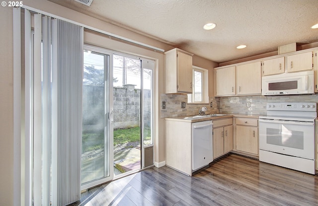 kitchen featuring white appliances, tasteful backsplash, wood finished floors, light countertops, and a textured ceiling