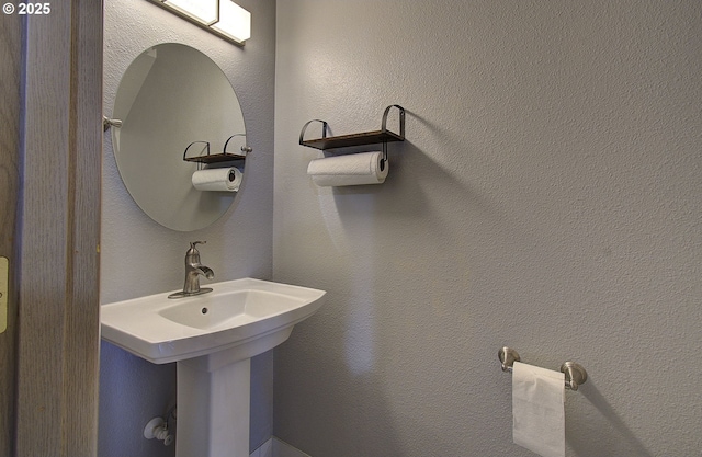 bathroom with a sink and a textured wall