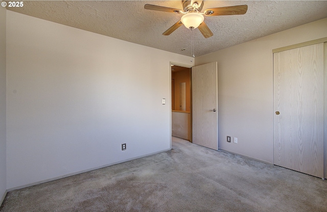 carpeted empty room with ceiling fan and a textured ceiling