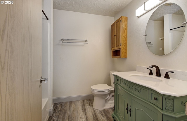 full bath featuring a shower, toilet, vanity, a textured ceiling, and wood finished floors