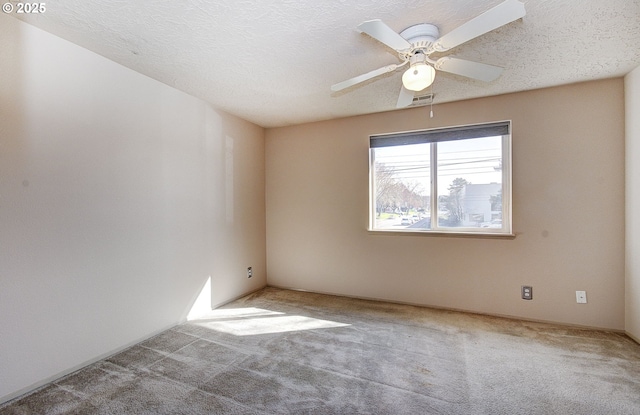 empty room featuring a textured ceiling, a ceiling fan, and carpet flooring