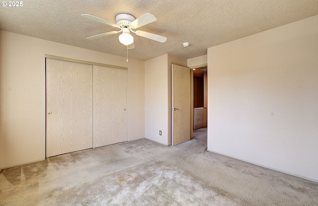 unfurnished bedroom featuring a ceiling fan, a closet, carpet flooring, and a textured ceiling