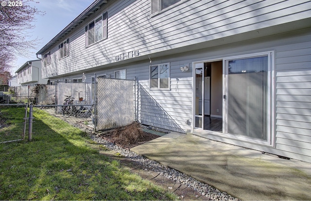 view of home's exterior with a patio area, fence, and a lawn