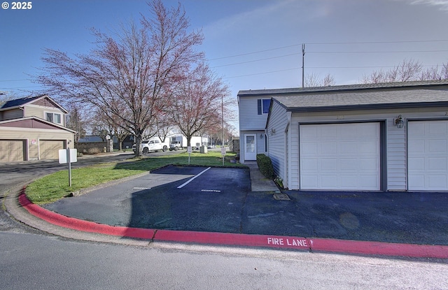 view of property exterior featuring a garage, roof with shingles, and a yard