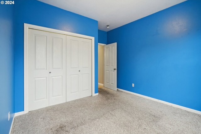 unfurnished bedroom featuring a closet and carpet flooring