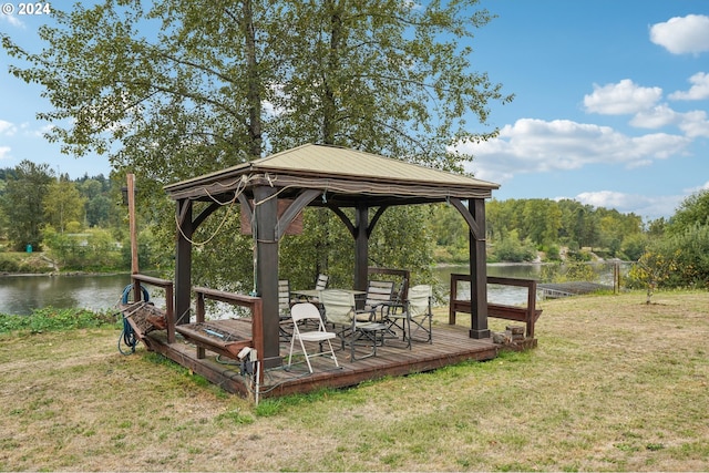 dock area with a lawn, a gazebo, and a deck with water view