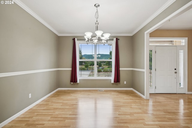 entryway with ornamental molding, light hardwood / wood-style flooring, and a chandelier