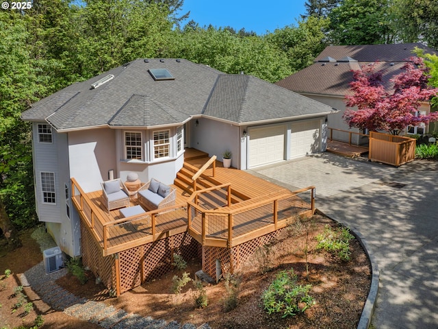 view of front of home featuring a garage, an outdoor hangout area, a deck, and central air condition unit