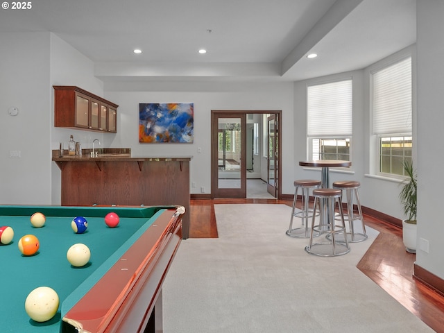 playroom with hardwood / wood-style flooring, a healthy amount of sunlight, wet bar, and pool table