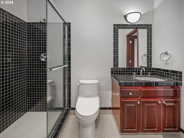 bathroom featuring vanity, tile patterned flooring, a shower with shower door, and toilet