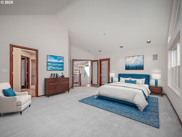 bedroom with ensuite bath, high vaulted ceiling, light carpet, and a notable chandelier