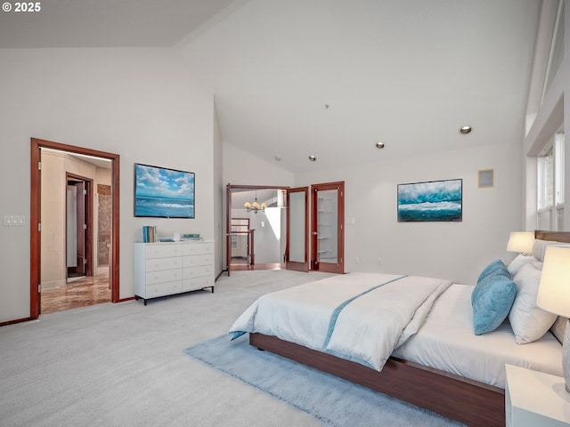 bedroom with light colored carpet, ensuite bathroom, a chandelier, and high vaulted ceiling