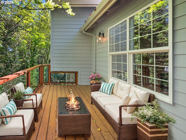 wooden deck with an outdoor living space with a fire pit