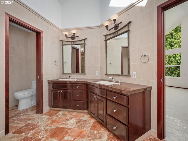 bathroom with vanity, tile walls, and toilet