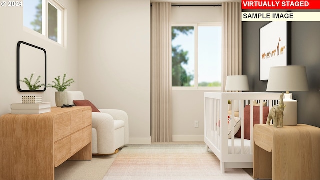 bedroom featuring a crib and light carpet