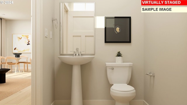 bathroom featuring hardwood / wood-style flooring and toilet