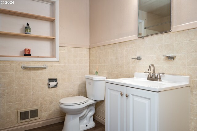 bathroom with vanity, toilet, hardwood / wood-style flooring, and tile walls