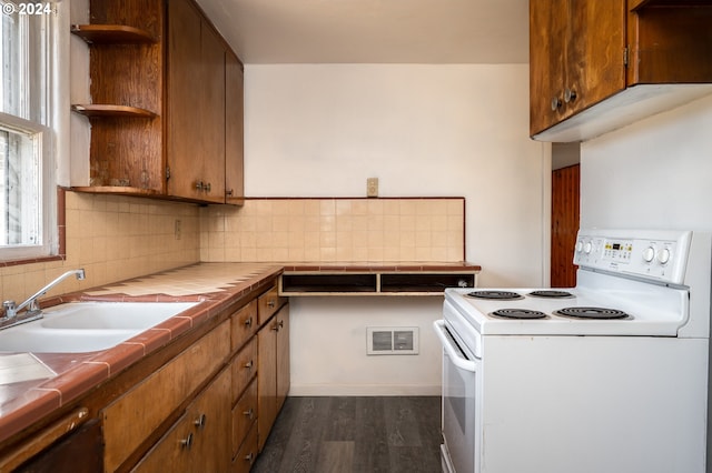 kitchen with dark hardwood / wood-style flooring, sink, white range with electric stovetop, tile counters, and decorative backsplash