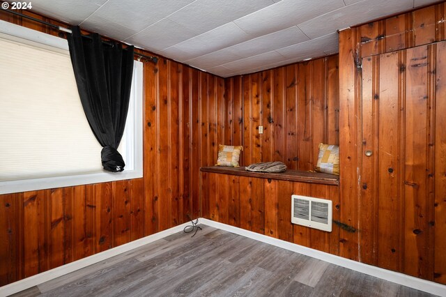 empty room with wood walls and wood-type flooring