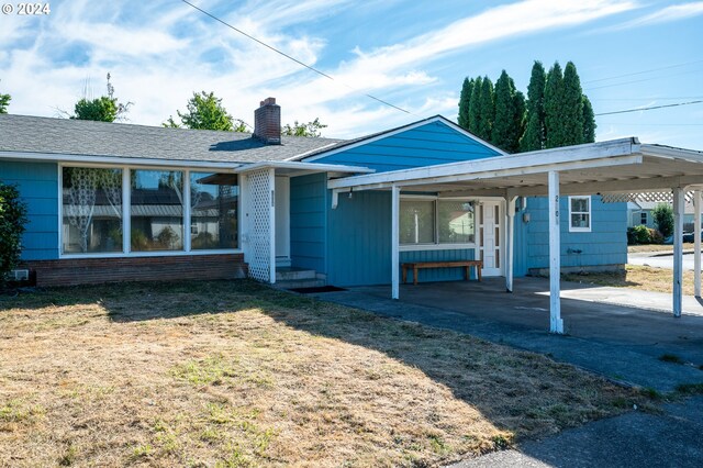 view of front of house with a front lawn and a carport