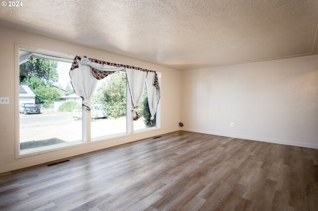 spare room featuring a textured ceiling and hardwood / wood-style flooring